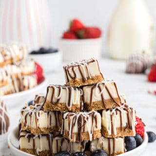 Side view of white plate stacked with No Bake Cheesecake Bites