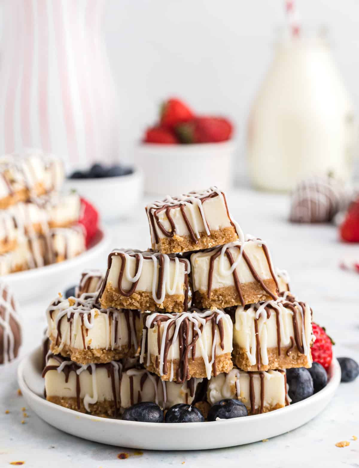 Side view of white plate stacked with No Bake Cheesecake Bites
