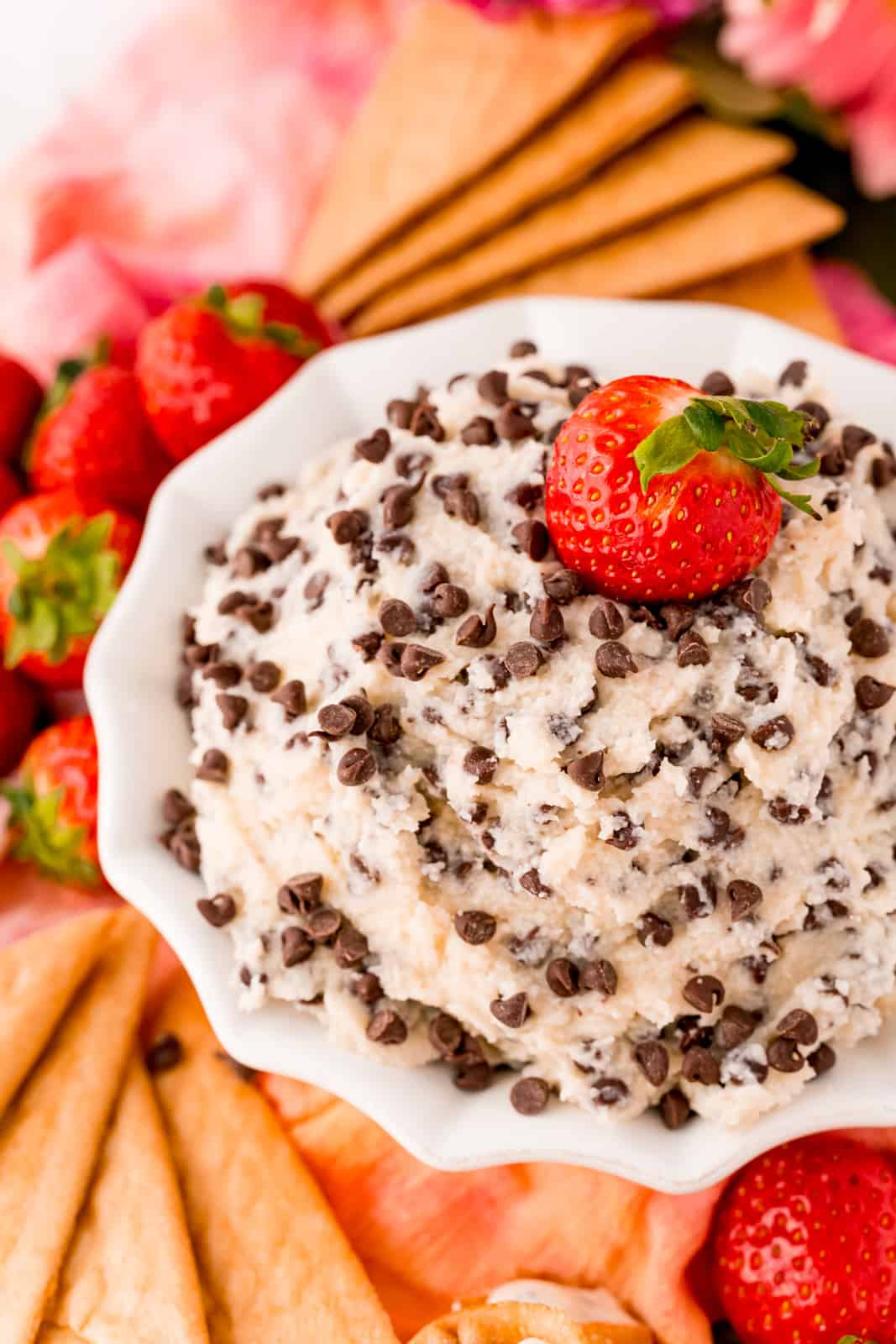 Angled view of dip in bowl with strawberry surrounded by dipping options