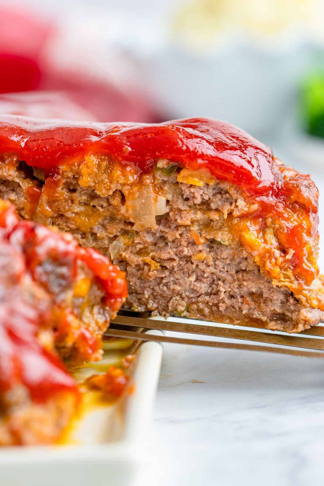 Spatula pulling a piece of meatloaf out of slices