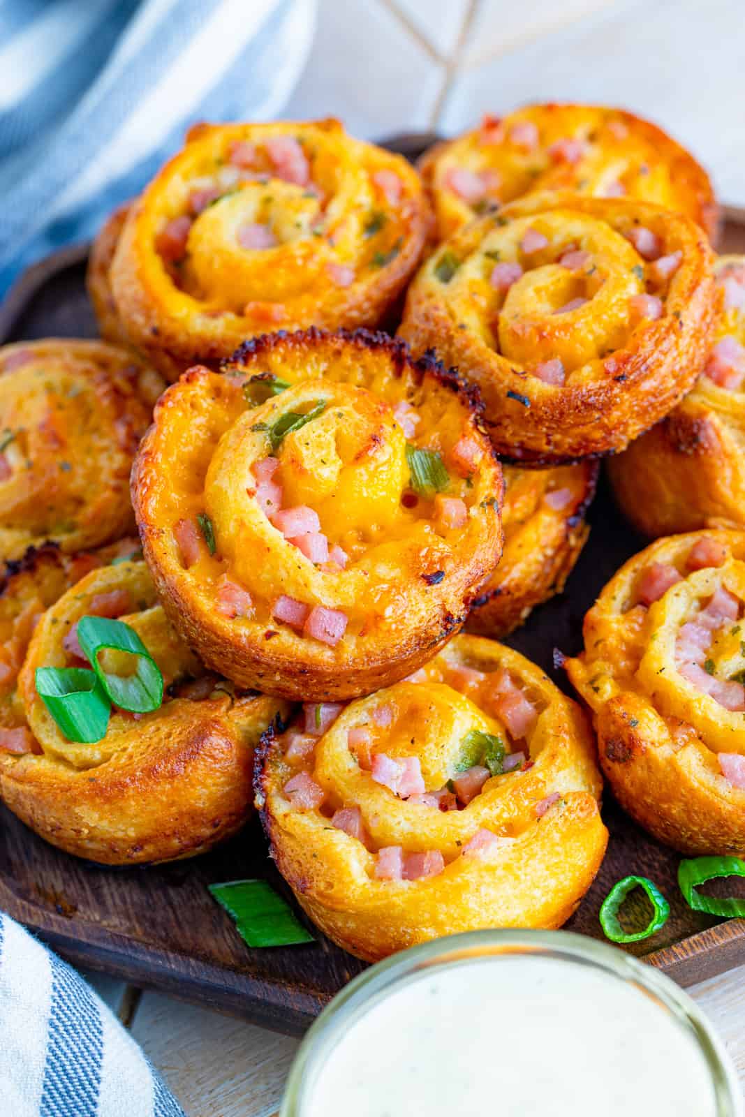 Ham and Cheese Pinwheels stacked on plate with a side of ranch