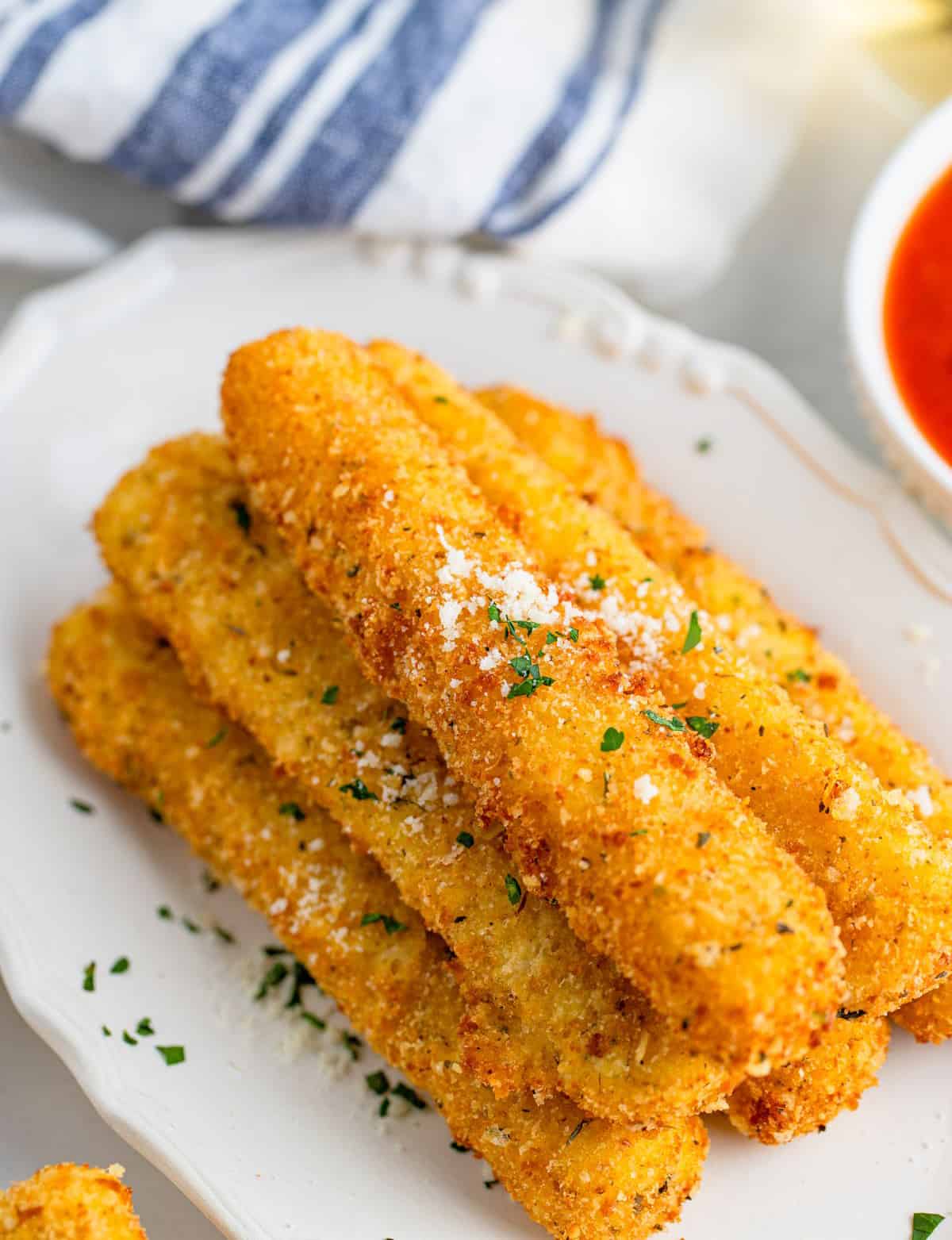 Overhead photo of stacked Mozzarella Sticks with parmesan and parsley