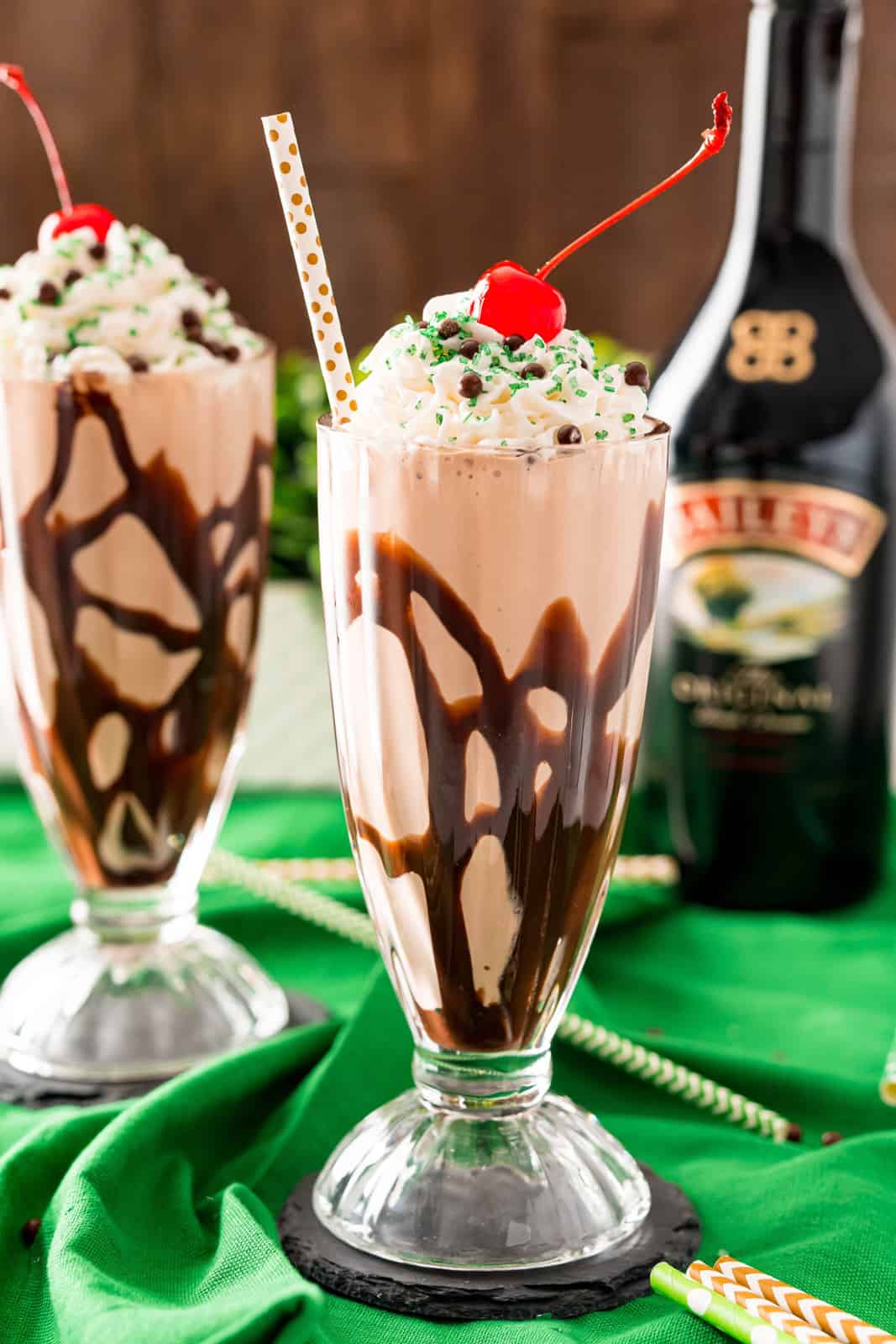 Close up of Chocolate Milkshake with glass drizzled in chocolate and topped with cherry