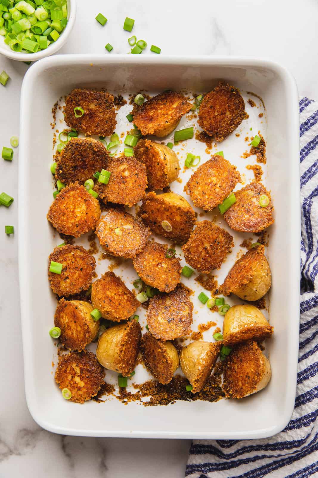 Overhead photo of finished potatoes in baking dish with green onions