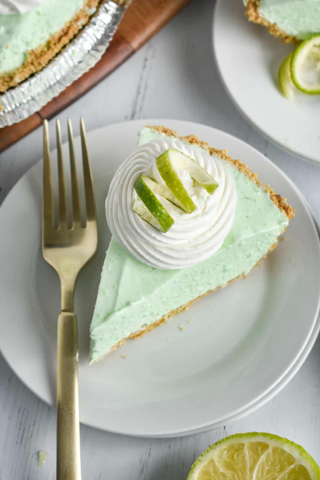 Overhead of Jello Pie on white plate with whipped topping and lime zest