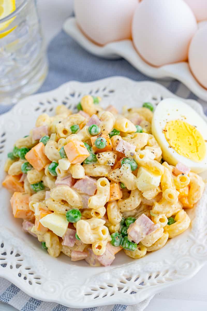 Macaroni Salad Recipe no white plate with half a hard-boiled egg