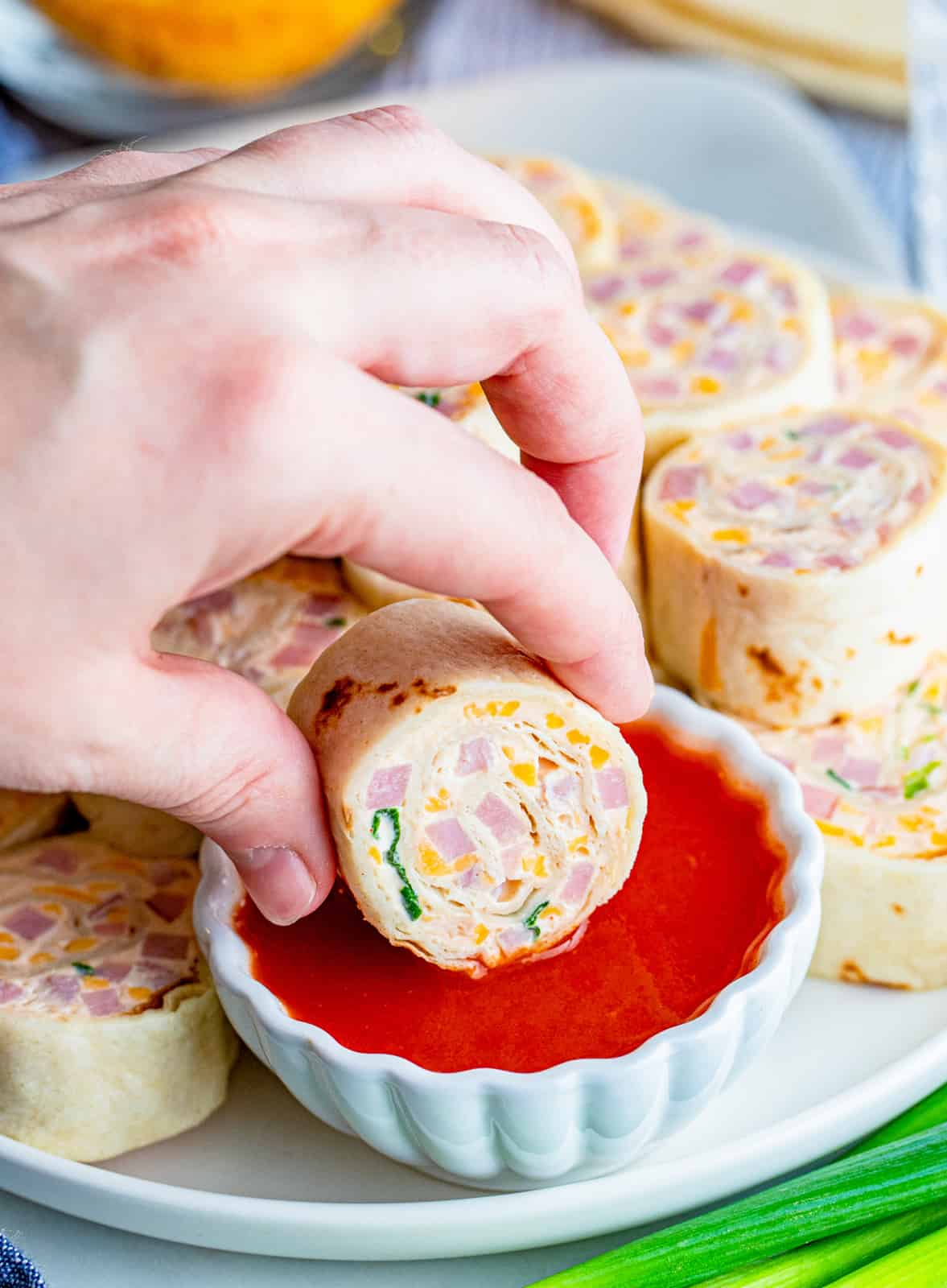 One Mississippi Dip Pinwheel Recipe being dipped in hot sauce