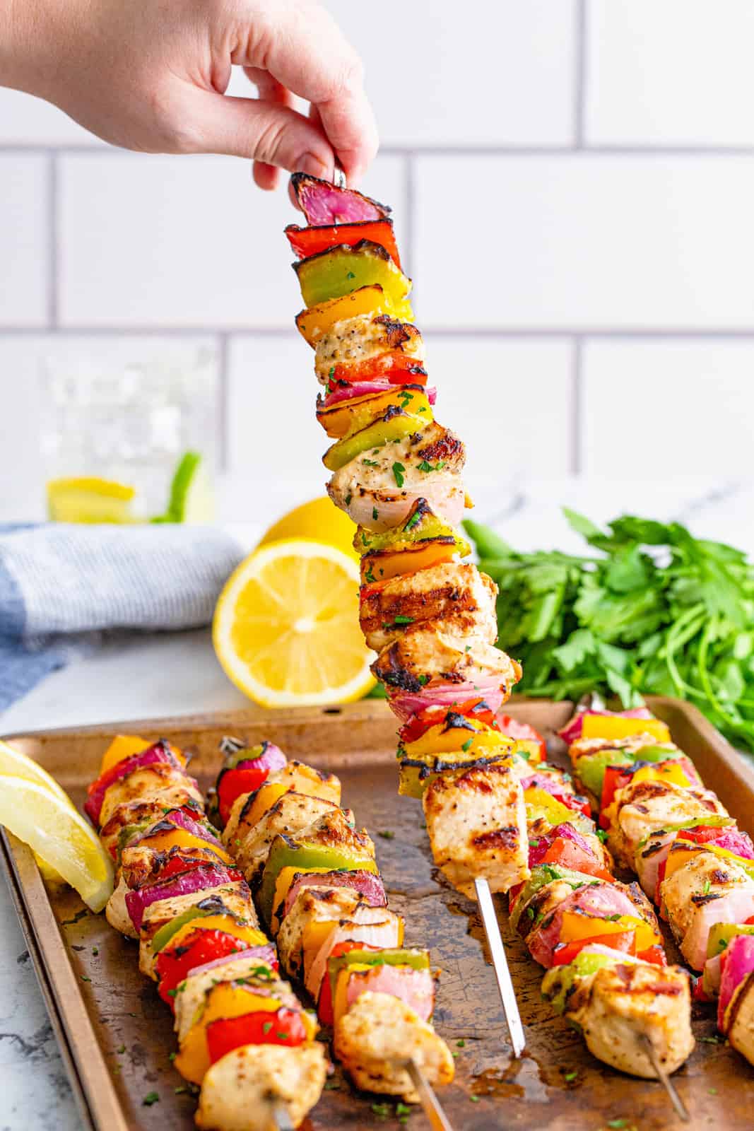 Hand holding up one the lemon pepper skewers