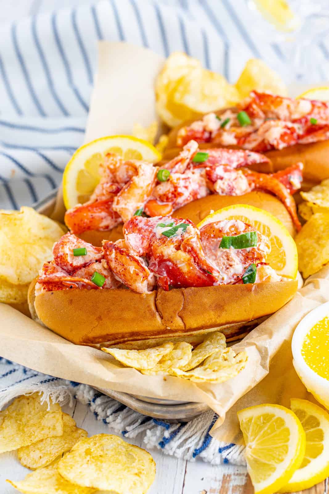 Lobster Roll Recipe on parchment lined tray with chips