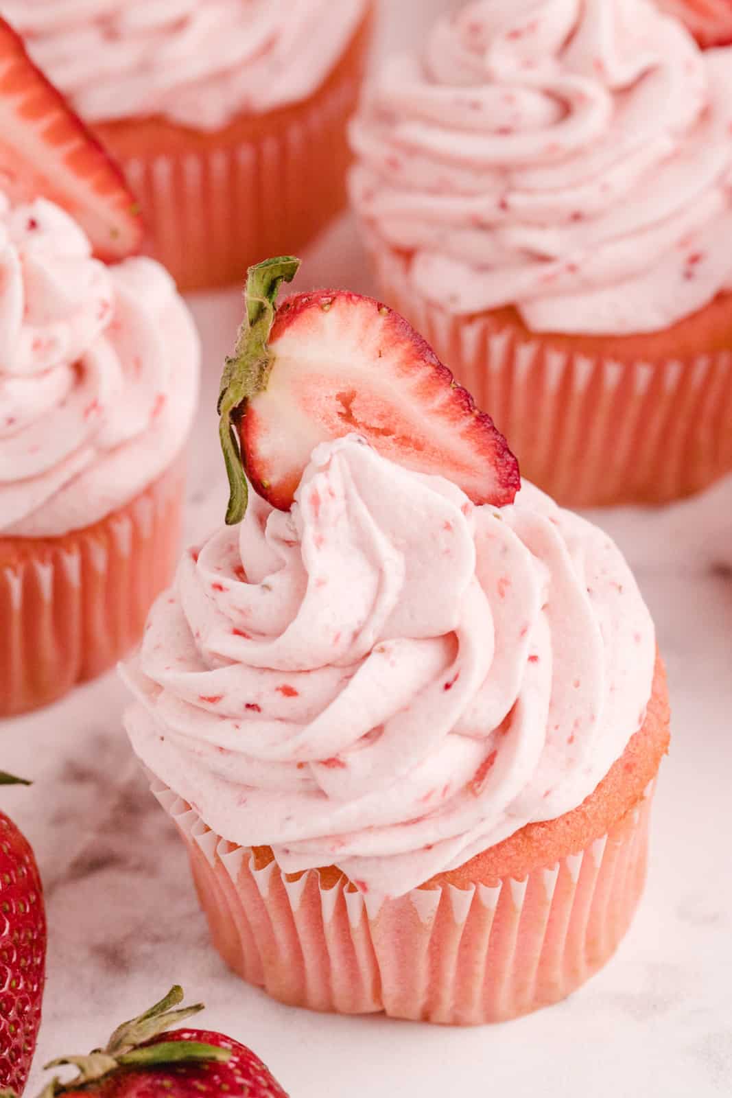 Closeup of one cupcake topped with strawberry slice