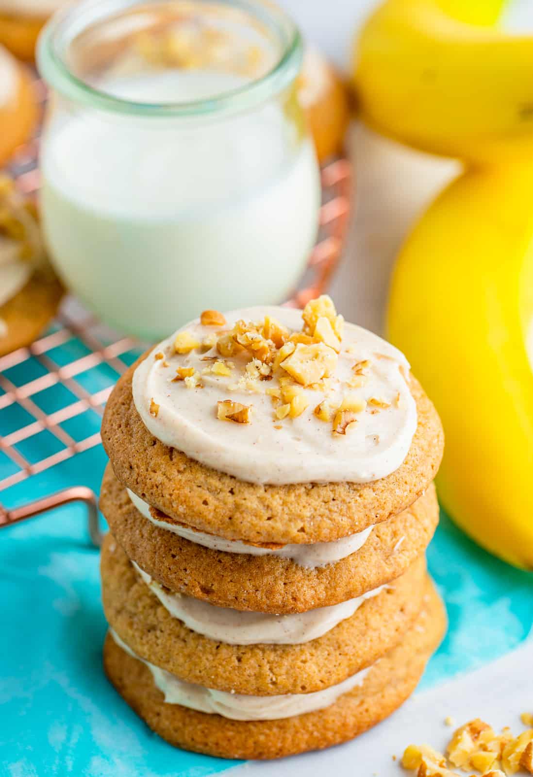Four stacked Banana Cookies with milk in background