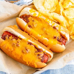 Square overhead photo of two finished hot dogs with chips