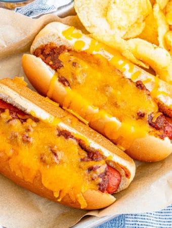 Square overhead photo of two finished hot dogs with chips