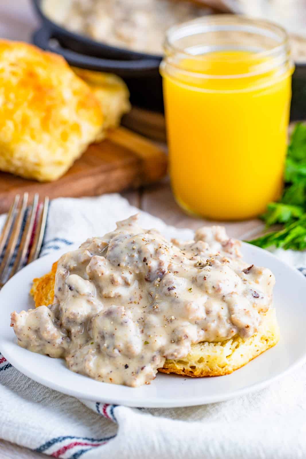 Plate of Biscuits and Gravy with orange juice in back