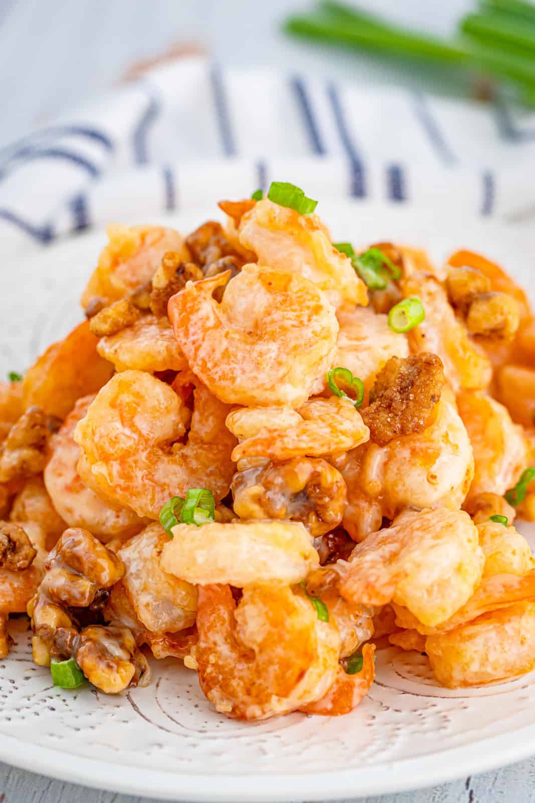 Honey Walnut Shrimp on white plate topped with green onions