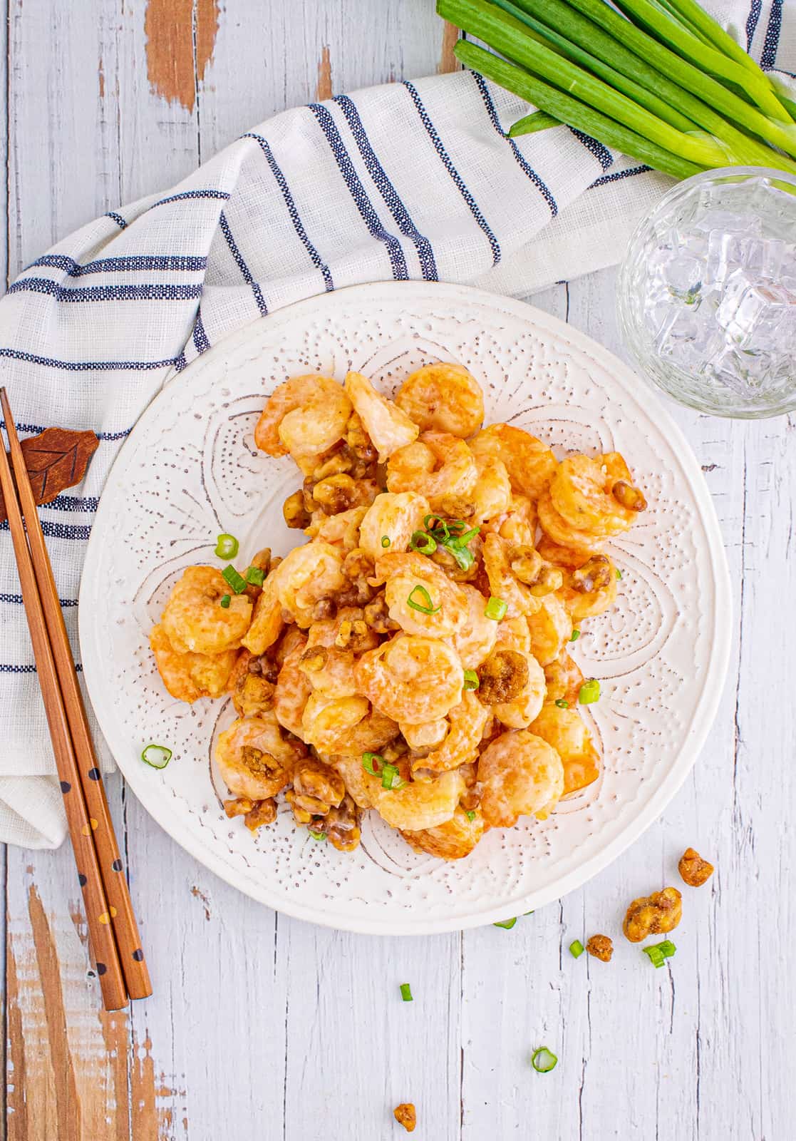 Overhead of Honey Walnut Shrimp on plate with chopsticks and green onions