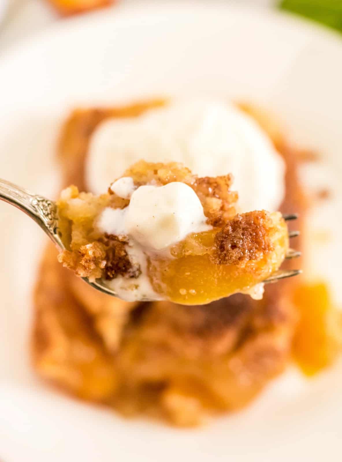 Fork holding up a bite out of the Peach Dump Cake Recipe 