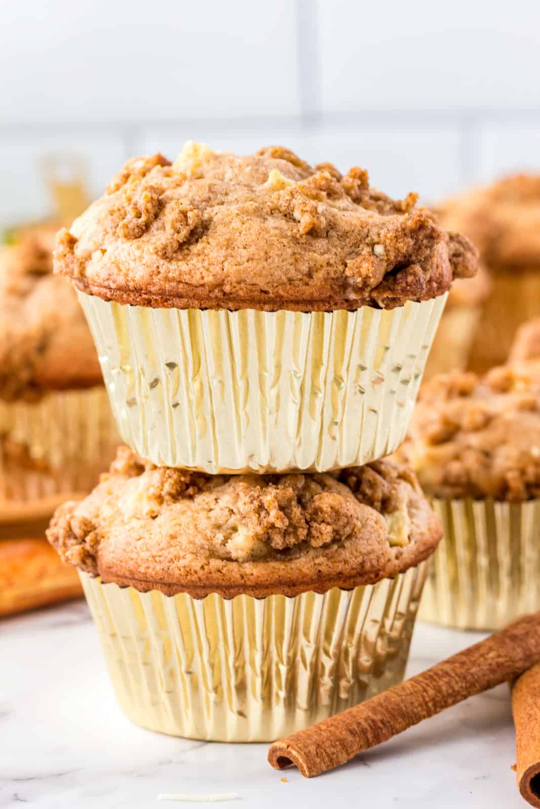 Two stacked Apple Cinnamon Muffins in gold muffin liners.
