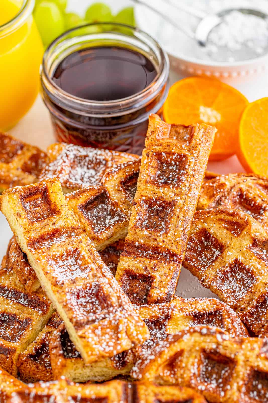 Close up of Waffle Sticks with syrup and oranges.