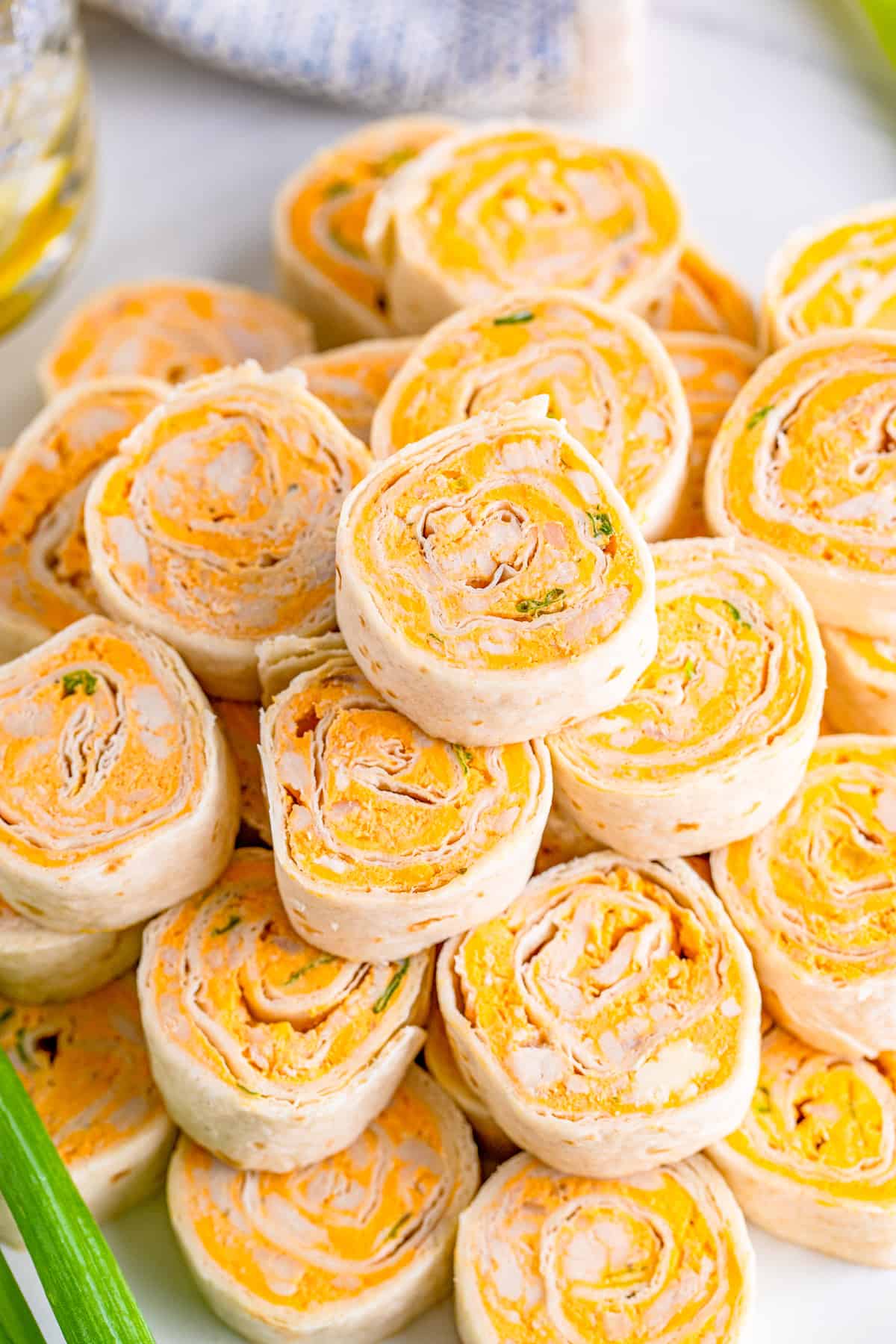 Overhead of stacked Buffalo Chicken Pinwheels on white tray.