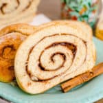 Slices of Cinnamon Swirl Bread on light blue/green plate with cinnamon stick square image.