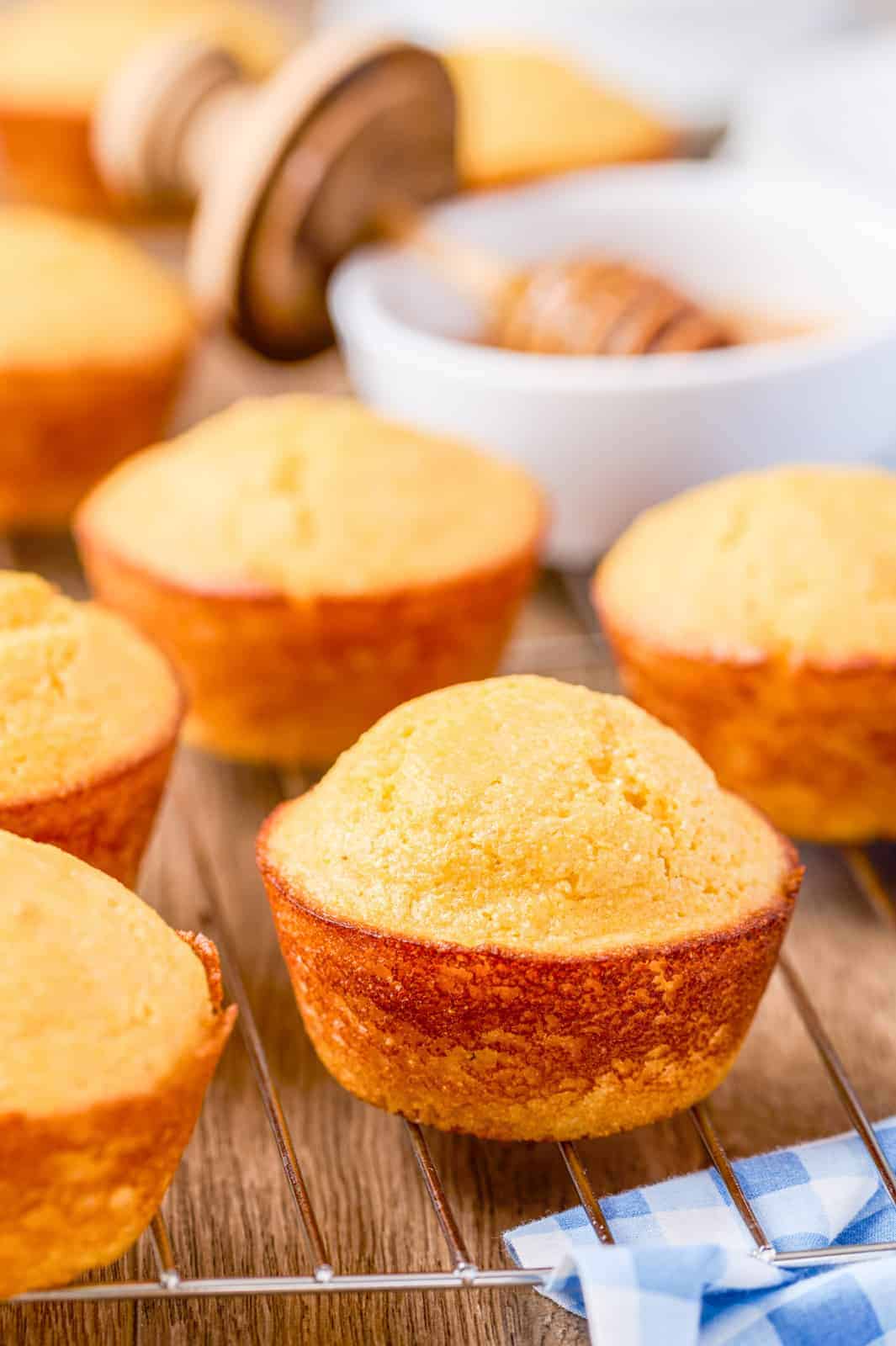 Cornbread Muffins on wire rack with honey in background.