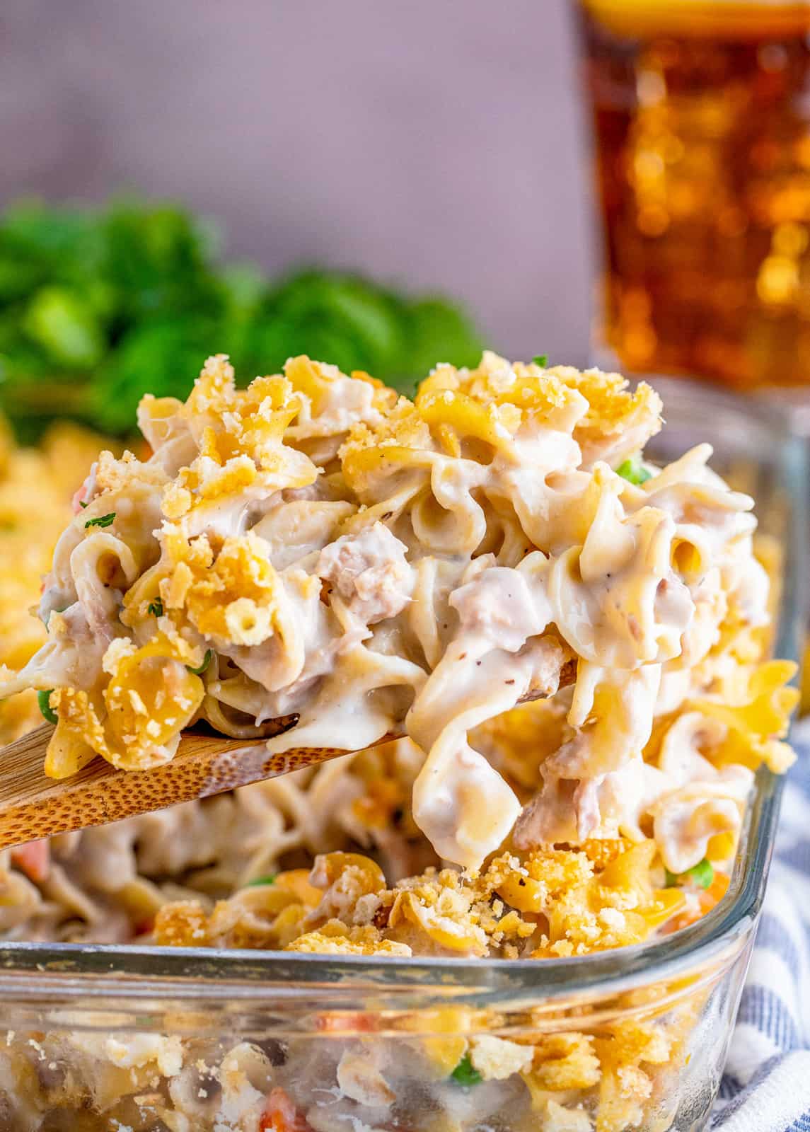 Wooden spoon scooping the Tuna Noodle Casserole Recipe out of baking pan.