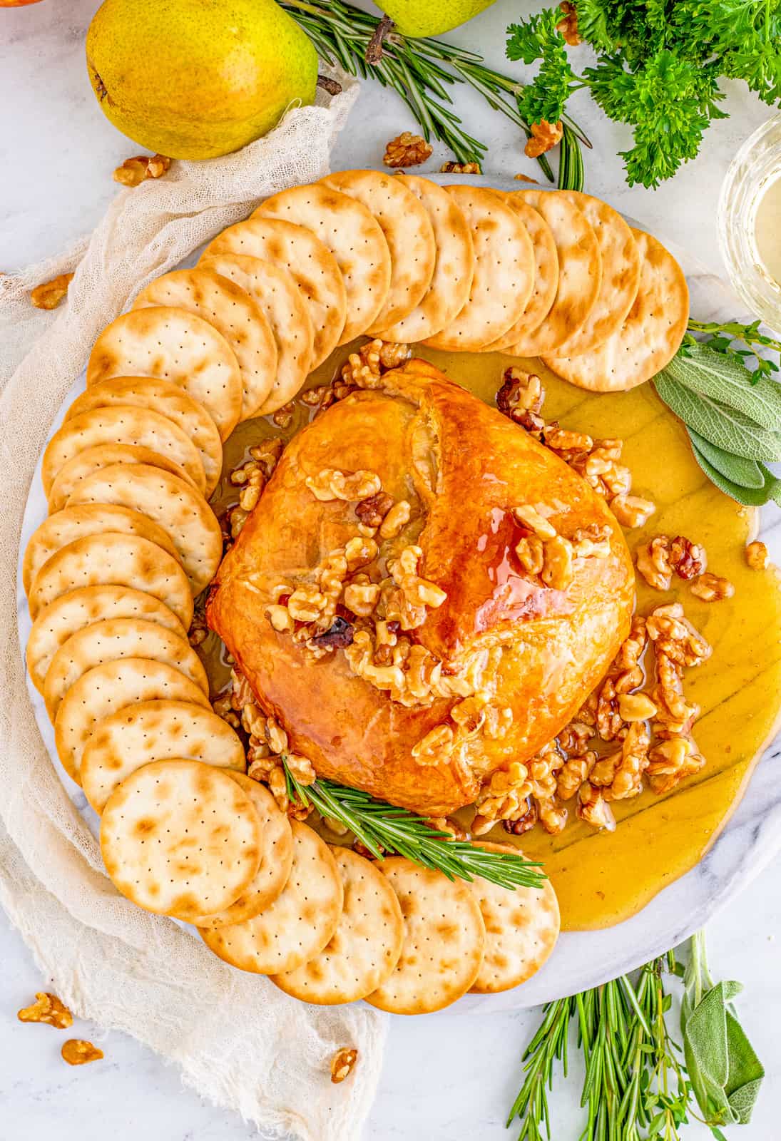 Overhead photo of styled Honey Walnut Baked Brie on marble tray