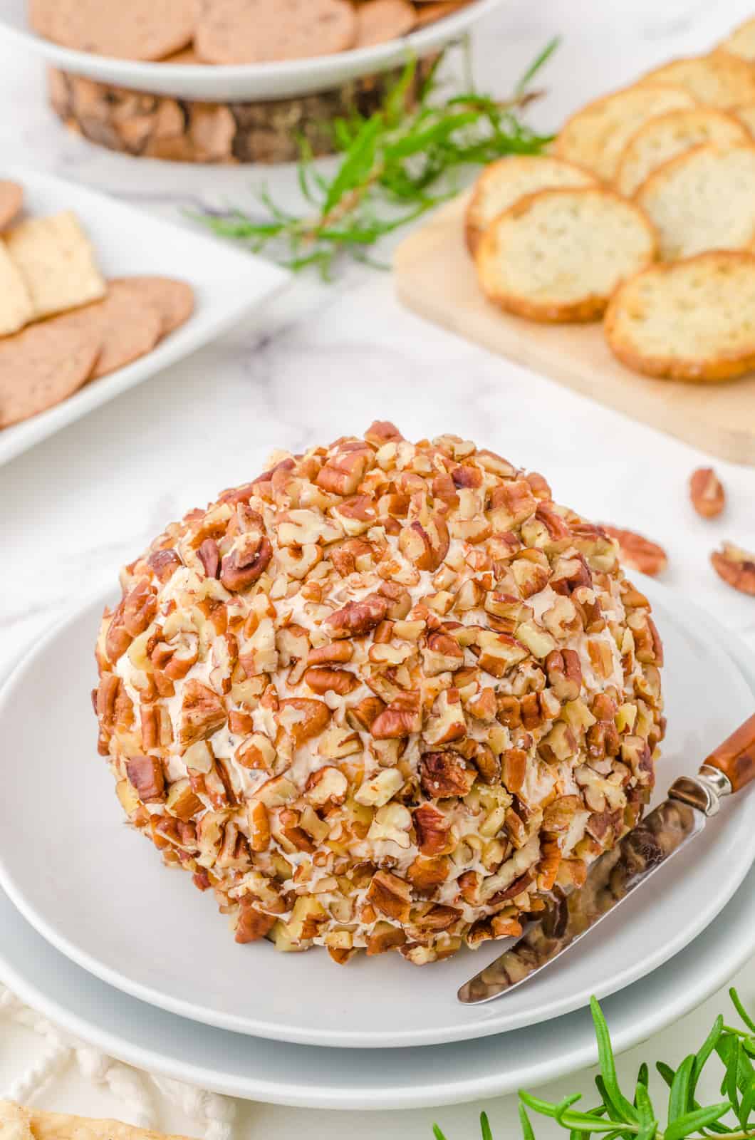 Sun-Dried Tomato Cheese Ball Recipe on plate with fork and dippers in background.