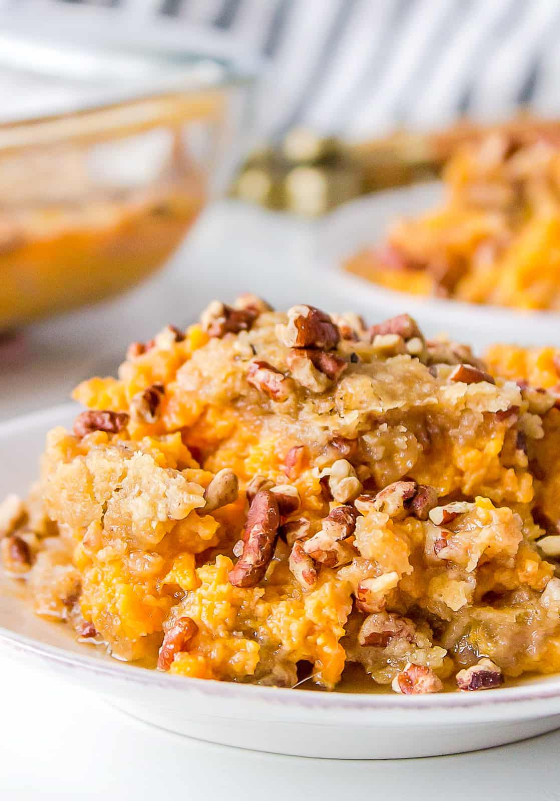 Plated Sweet Potato Casserole Recipe on white plate with dish behind it.