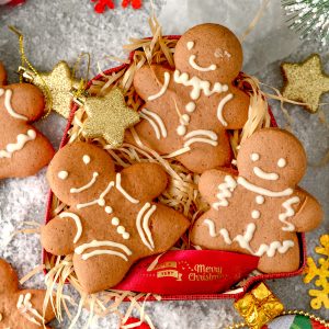 Square image of cookies in box with holiday decorations.