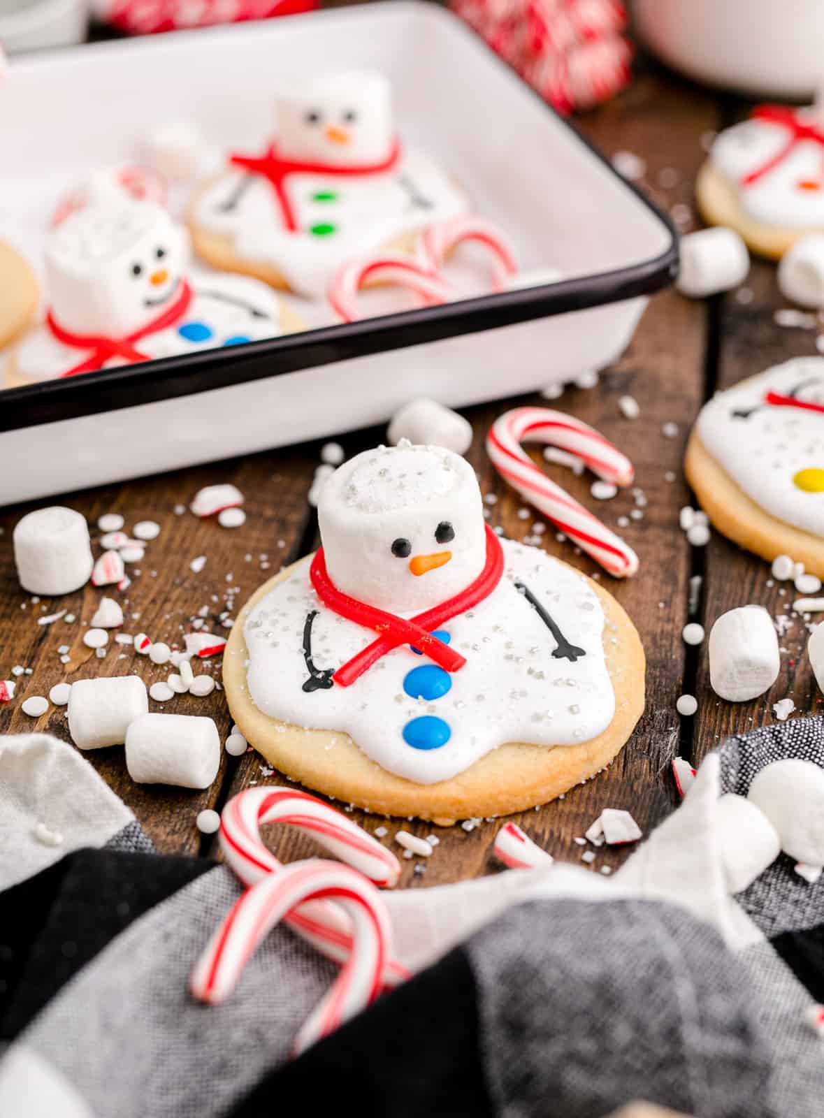 Melted Snowman Cookie with a tray of cookies in back.