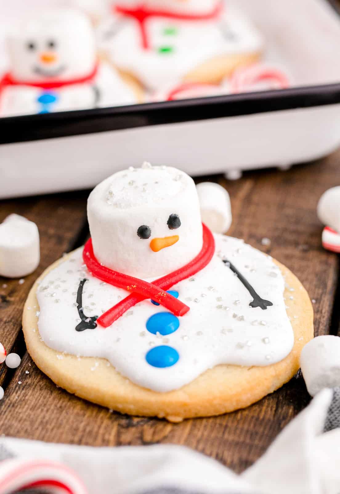 Close up of one Melted Snowman Cookie decorated on wooden background.