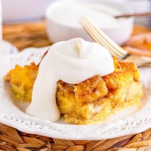 Square image of slice of bread pudding with whipped topping