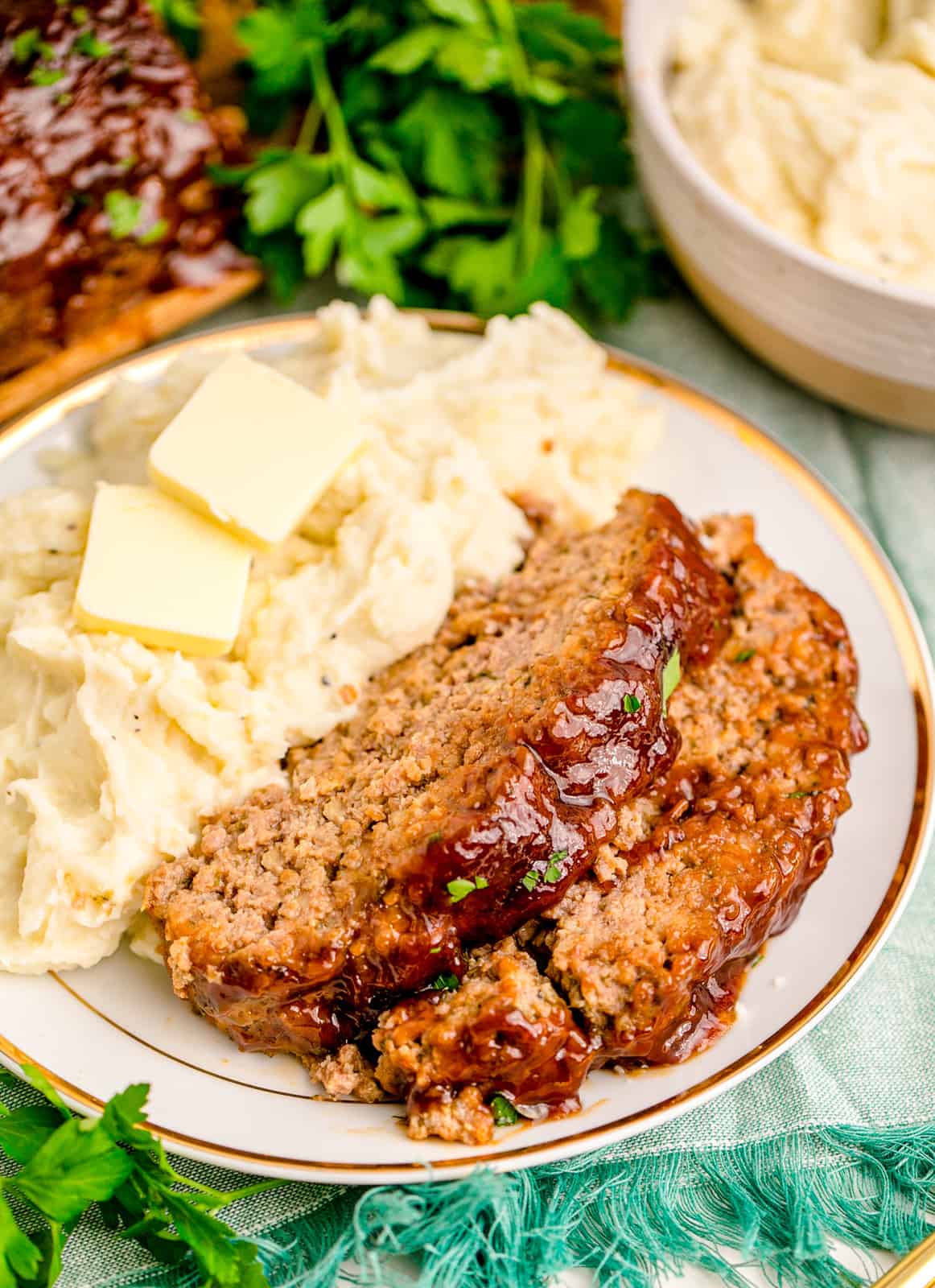 Slices of Instant Pot Meatloaf with mashed potatoes on white plate.