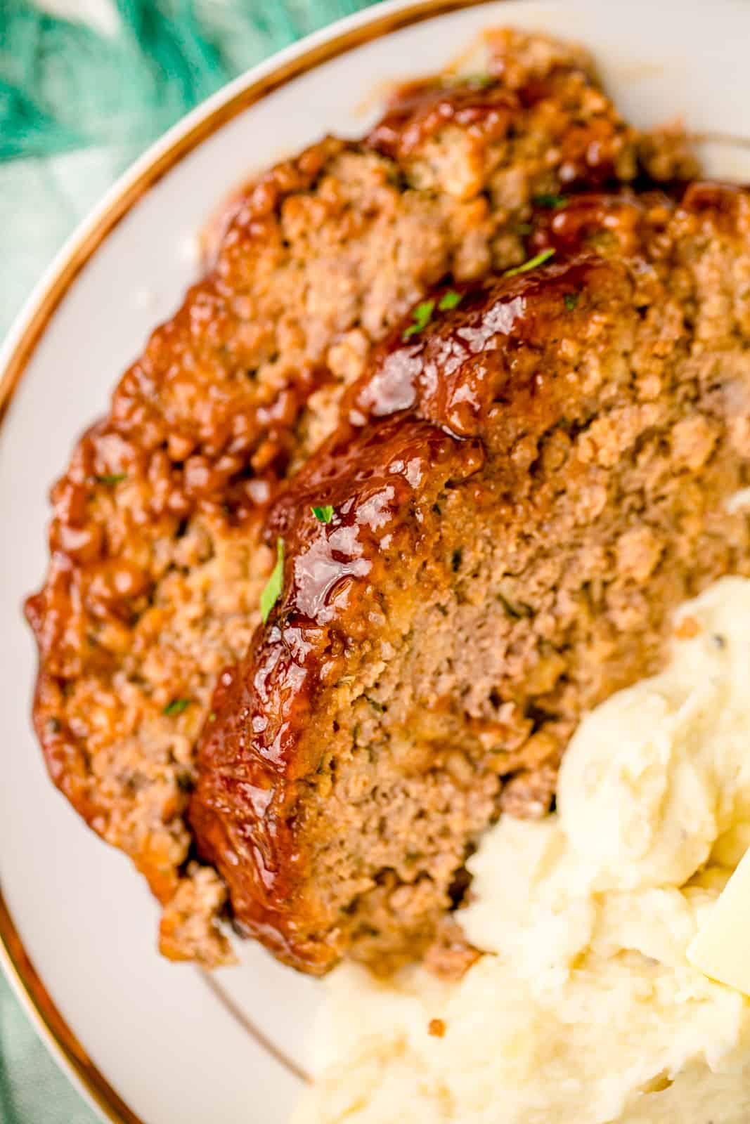 Close up of slices of meatloaf with mashed potatoes.