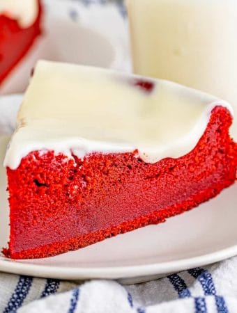 Square image of a slice of Red Velvet Ricotta Cake on white plate.