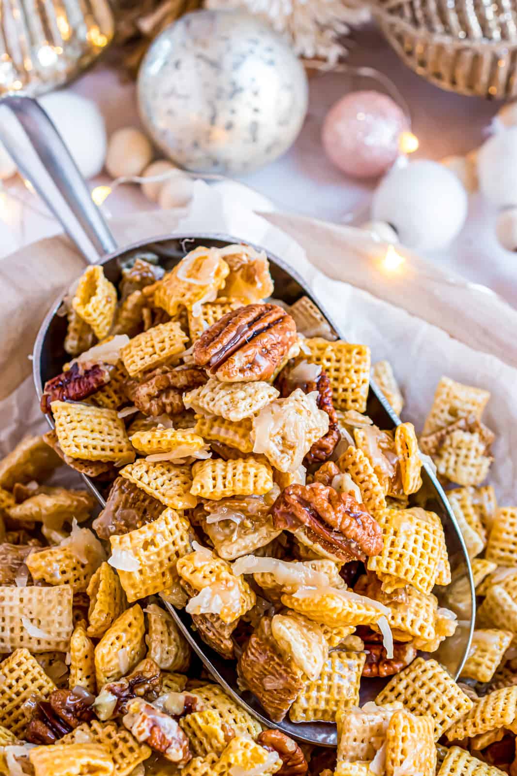 Close up of scoop in basket with Holiday Chex Mix.
