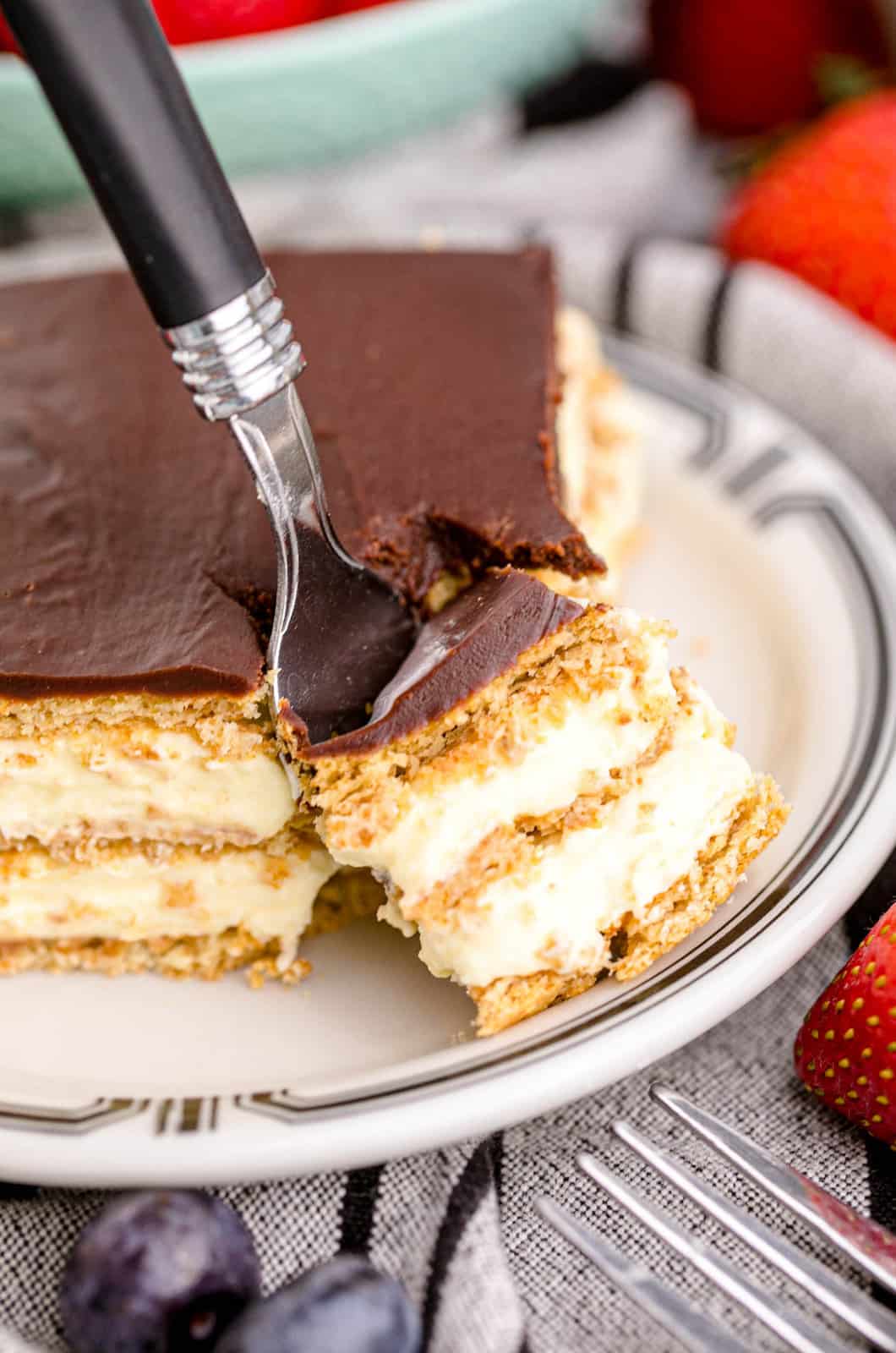 Fork going into slice of Eclair Cake removing a bite.