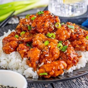 Square image of chicken finished over a bed or rice.