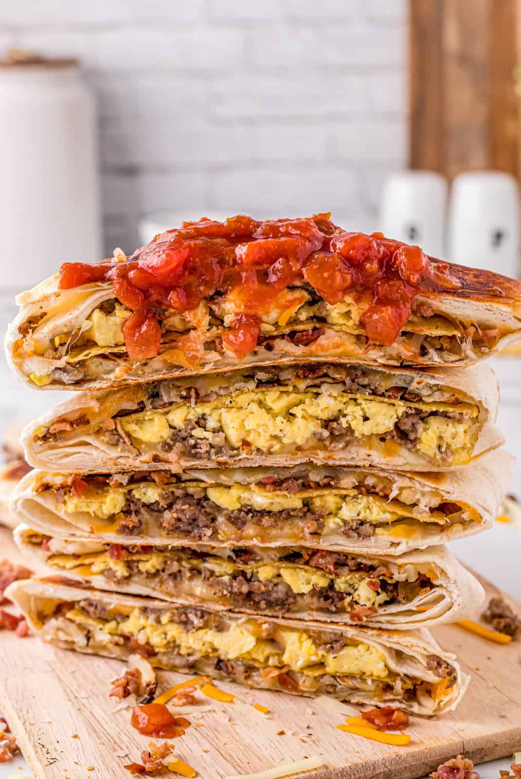Breakfast Crunchwrap cut in half and stacked topped with salsa.
