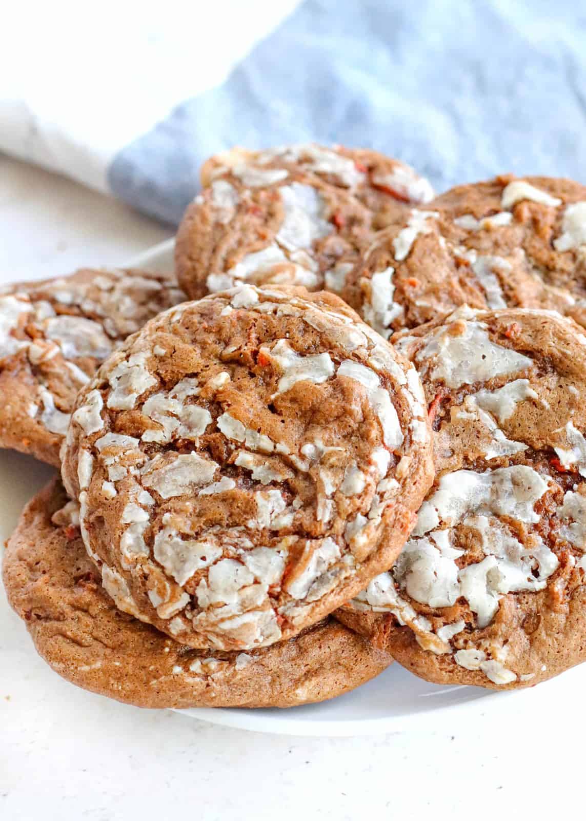 Cream Cheese Carrot Cake Cookies stacked on white plate.