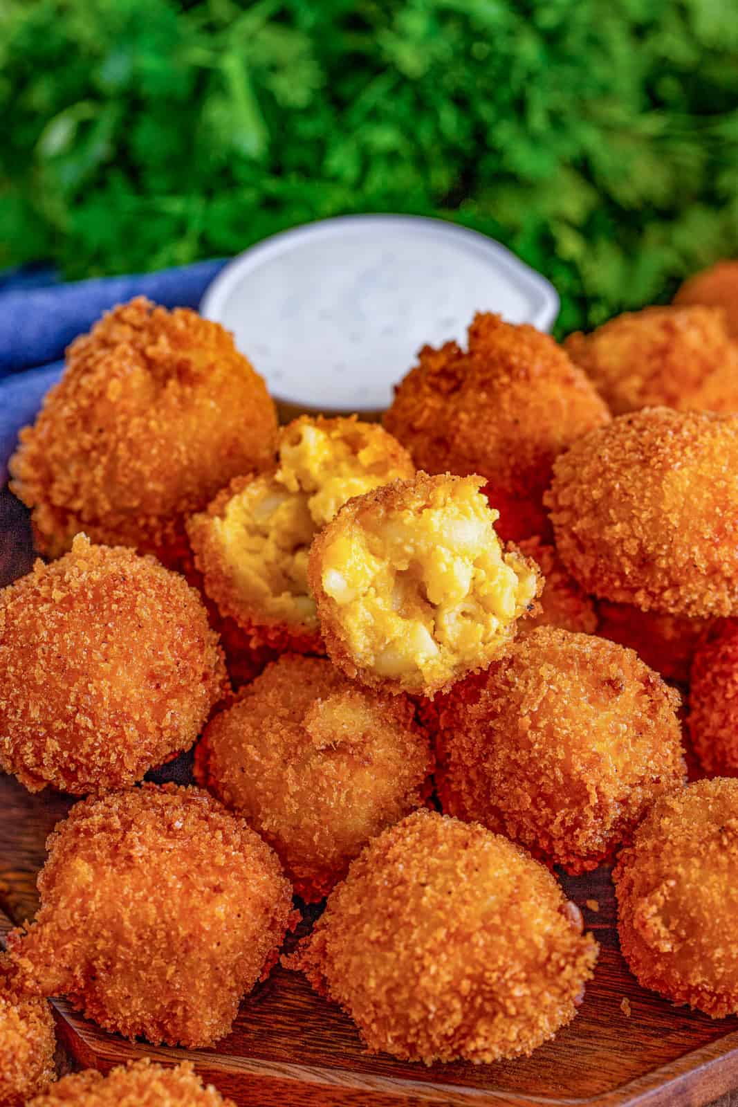 Pile of Fried Mac and Cheese Balls with one open on top of stack.