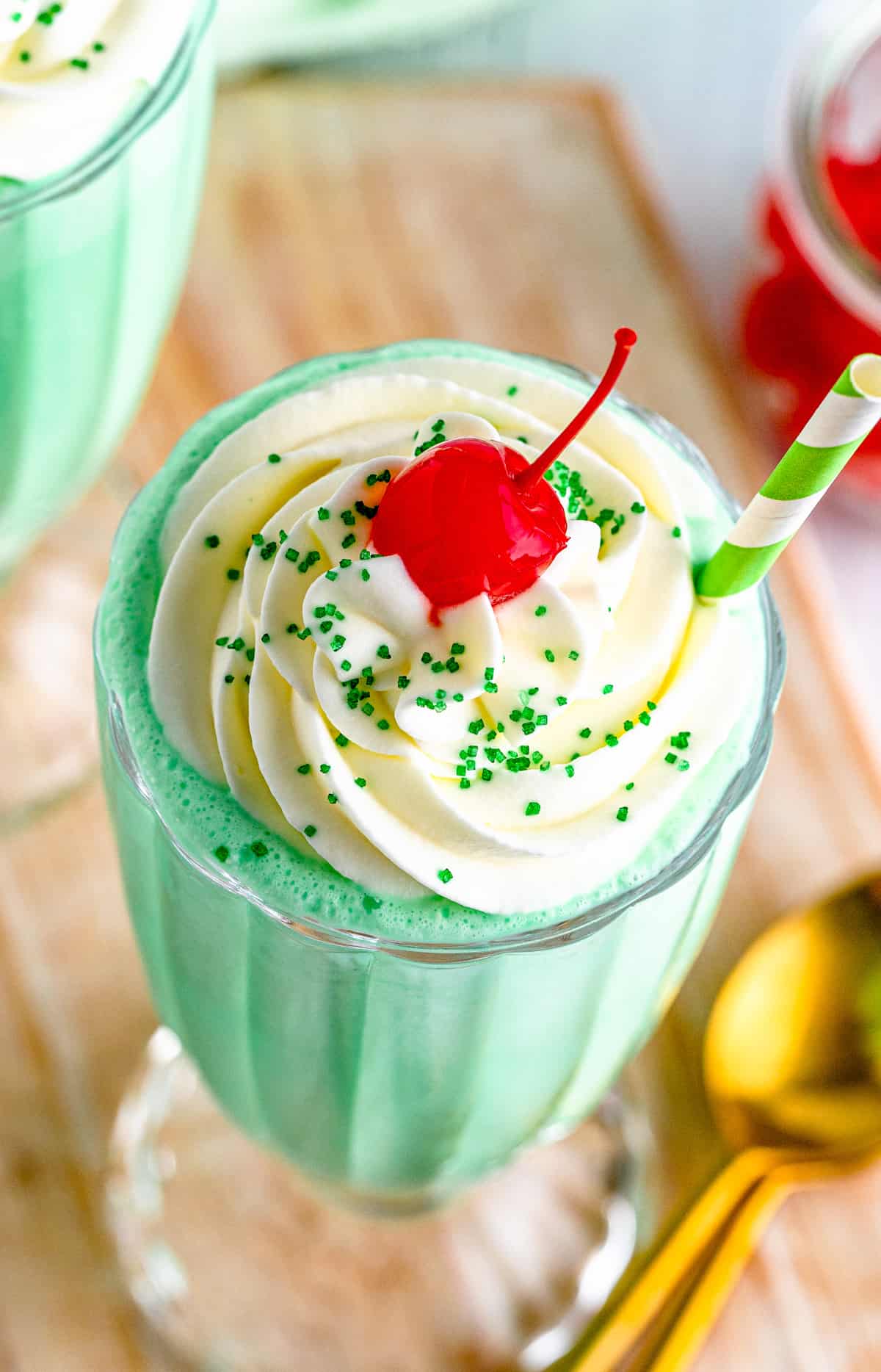 Close up overhead of shake showing the whipped cream, cherry and green sprinkles.