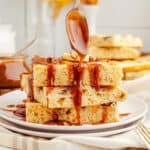 Square image of stacked pancakes with spoon drizzling sauce over them.