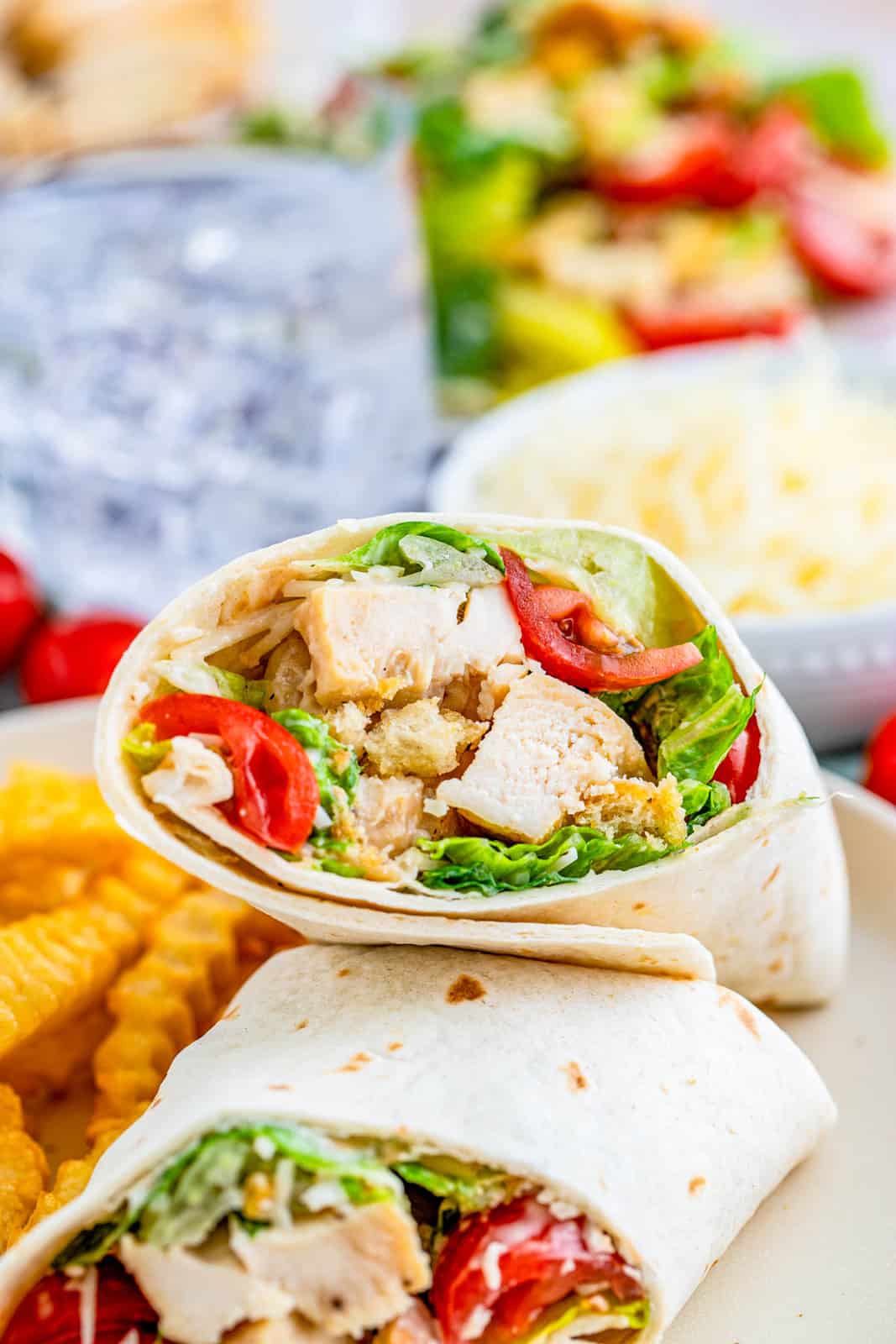 Chicken Caesar Wraps cut in half with one showing ingredients inside.