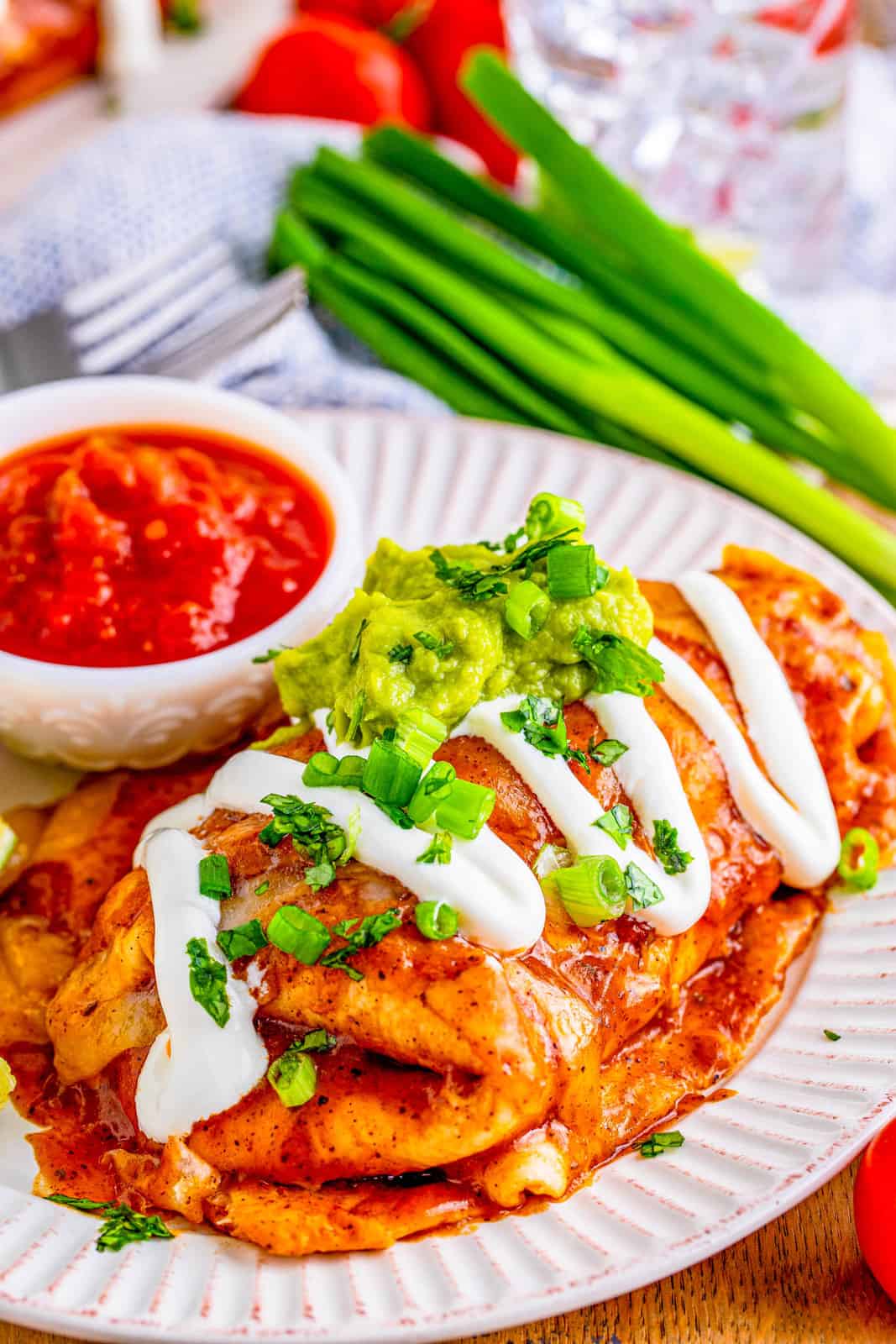 Smothered Beef Burritos on plate with garnishes.
