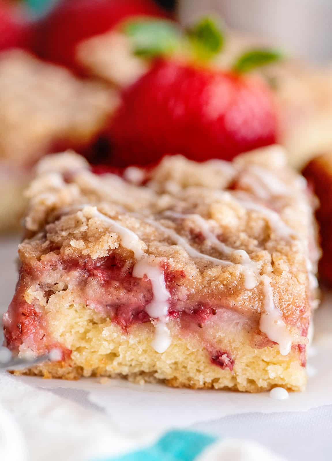 Slice of Strawberry Coffee Cake on parchment paper with glaze.