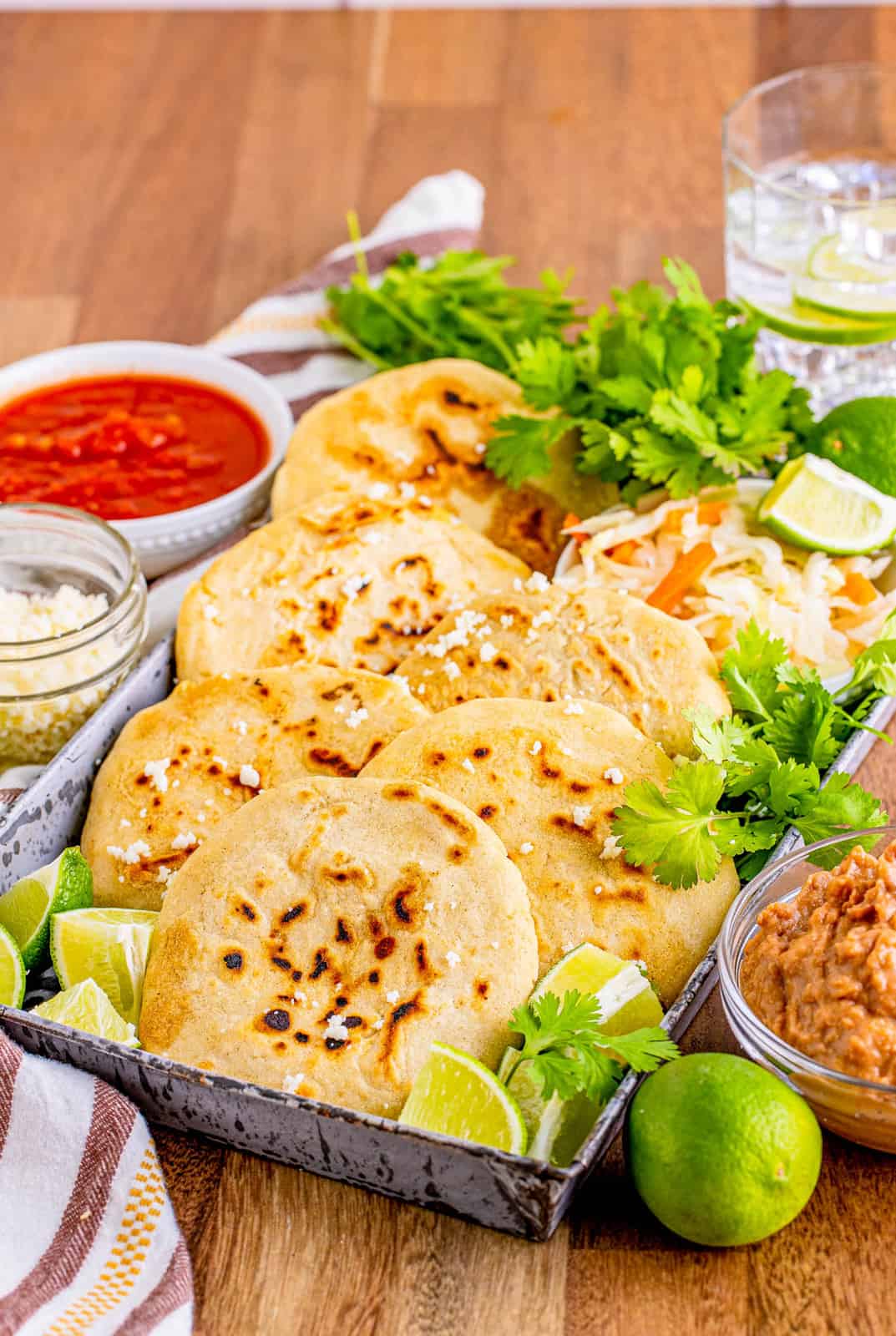 Pupusas Recipe layered with garnishes and dipping sauces.