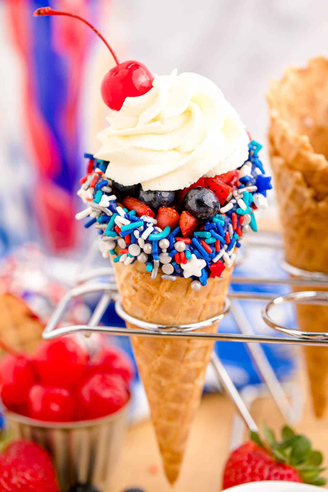 Close up of one Fruit Cone topped with whipped cream and a cherry.